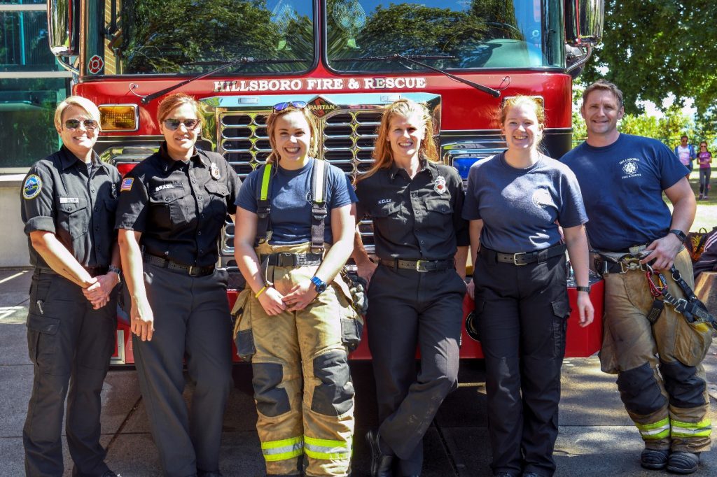 Six firefighters standing in front of a red fire truck