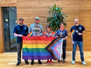 Port employees carrying an inclusive Pride flag